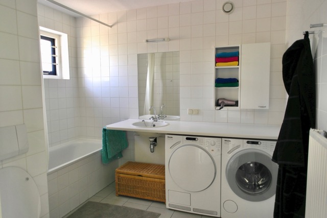 Ruime badkamer met wasmachine en droger